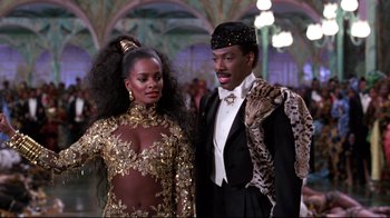 Movie still from “Coming to America” (1988), directed by John Landis – A man and a woman dressed up in costume; Medium shot, Low angle