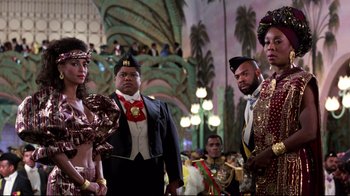 Movie still from “Coming to America” (1988), directed by John Landis – A group of men and women standing next to each other; Medium shot, Over the shoulder angle