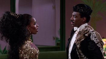 Movie still from “Coming to America” (1988), directed by John Landis – A man and a woman are standing next to each other; Medium shot, Low angle