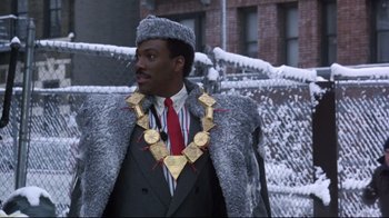 Movie still from “Coming to America” (1988), directed by John Landis – A man wearing a fur coat and a red hat; Close Up shot, Low angle