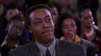 Movie still from “Coming to America” (1988), directed by John Landis – A person wearing a suit and tie; Close Up shot, Low angle