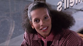 Movie still from “Coming to America” (1988), directed by John Landis – A person smiling for the camera; Close Up shot, Low angle