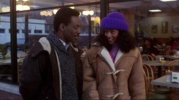Movie still from “Coming to America” (1988), directed by John Landis – A man and a woman standing next to each other; Medium shot, Over the shoulder angle