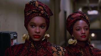 Movie still from “Coming to America” (1988), directed by John Landis – A woman in a head scarf is standing next to another woman; Close Up shot, Low angle