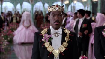 Movie still from “Coming to America” (1988), directed by John Landis – A man wearing a crown in front of a group of people; Close Up shot, Low angle