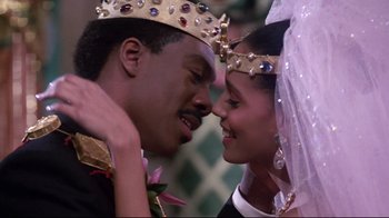 Movie still from “Coming to America” (1988), directed by John Landis – A man and a woman wearing a crown and holding hands; Close Up shot, Low angle