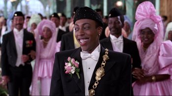 Movie still from “Coming to America” (1988), directed by John Landis – A man in a suit and a hat is smiling; Close Up shot, Low angle