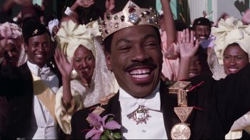 Movie still from “Coming to America” (1988), directed by John Landis – A man wearing a tiara and a crown; Close Up shot, Low angle