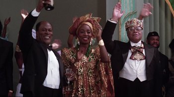 Movie still from “Coming to America” (1988), directed by John Landis – A group of men and women in formal wear holding glasses; Medium shot, Low angle