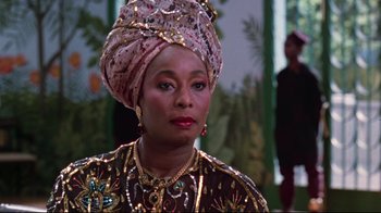 Movie still from “Coming to America” (1988), directed by John Landis – An older woman wearing a head scarf and a necklace; Close Up shot, Low angle