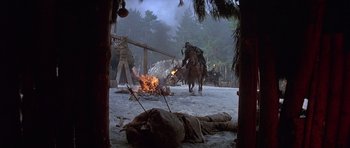 Movie still from “Conan the Barbarian” (1982), directed by John Milius – A group of people on horses near a fire; Wide shot, High angle