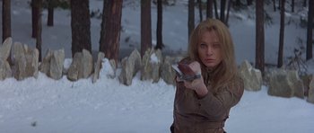 Movie still from “Conan the Barbarian” (1982), directed by John Milius – A woman holding a cell phone while standing in the snow; Medium shot, Low angle