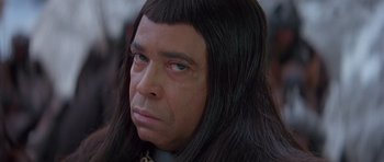 Movie still from “Conan the Barbarian” (1982), directed by John Milius – A person with long black hair; Close Up shot, High angle