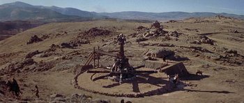 Movie still from “Conan the Barbarian” (1982), directed by John Milius – An old fashioned well in the middle of the desert; Extreme Wide shot, High angle