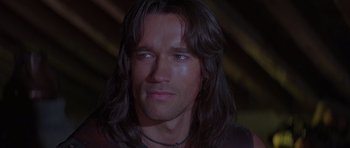 Movie still from “Conan the Barbarian” (1982), directed by John Milius – A person with long black hair; Close Up shot, Low angle