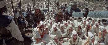 Movie still from “Conan the Barbarian” (1982), directed by John Milius – A group of people dressed in white towels; Extreme Wide shot, High angle