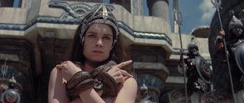 Movie still from “Conan the Barbarian” (1982), directed by John Milius – A woman wearing a helmet and a snake around her neck; Close Up shot, High angle