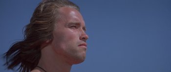 Movie still from “Conan the Barbarian” (1982), directed by John Milius – A man's face in the sunlight; Close Up shot, Low angle