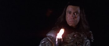 Movie still from “Conan the Barbarian” (1982), directed by John Milius – A man in a costume holding a candle in the dark; Close Up shot, Low angle
