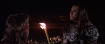 Movie still from “Conan the Barbarian” (1982), directed by John Milius – A man holding a burning candle in a dark place; Close Up shot, Low angle