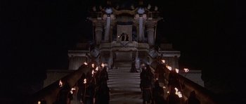 Movie still from “Conan the Barbarian” (1982), directed by John Milius – A group of people standing in front of a building; Extreme Wide shot, High angle