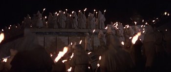 Movie still from “Conan the Barbarian” (1982), directed by John Milius – A group of people dressed in white holding torches; Wide shot, High angle