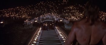 Movie still from “Conan the Barbarian” (1982), directed by John Milius – A group of people standing in a room with candles; Extreme Wide shot, High angle