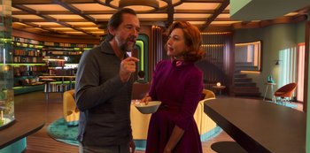 Movie still from “Big Bug” (2022), directed by Jean-Pierre Jeunet – A man and a woman are standing in front of a bowl; Medium shot, Over the shoulder angle