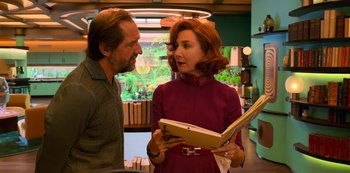 Movie still from “Big Bug” (2022), directed by Jean-Pierre Jeunet – A man and a woman looking at each other with an open book; Medium shot, Over the shoulder angle