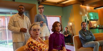 Movie still from “Big Bug” (2022), directed by Jean-Pierre Jeunet – A group of people sitting and standing in a living room; Medium shot, Low angle