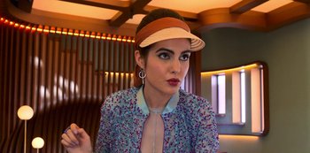 Movie still from “Big Bug” (2022), directed by Jean-Pierre Jeunet – A woman wearing a hat and wearing a dress; Close Up shot, Low angle