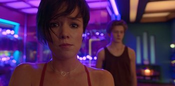 Movie still from “Big Bug” (2022), directed by Jean-Pierre Jeunet – A woman standing next to a man in front of a purple light; Close Up shot, Low angle