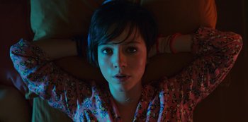 Movie still from “Big Bug” (2022), directed by Jean-Pierre Jeunet – A woman laying on the ground with her hands behind her head; Close Up shot, Overhead angle