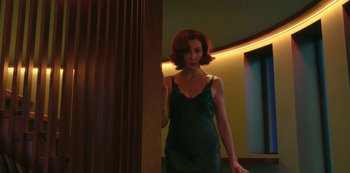 Movie still from “Big Bug” (2022), directed by Jean-Pierre Jeunet – A woman in a green dress standing next to a wooden pole; Medium shot, Low angle