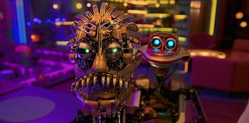 Movie still from “Big Bug” (2022), directed by Jean-Pierre Jeunet – A robot head with glowing green eyes next to another robot head; Extreme Close Up shot, Low angle