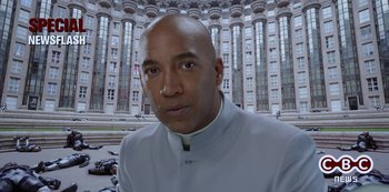 Movie still from “Big Bug” (2022), directed by Jean-Pierre Jeunet – A man wearing a white suit standing in front of a tall building; Close Up shot, Low angle