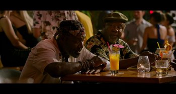 Movie still from “Da 5 Bloods” (2020), directed by Spike Lee – Two men sitting at a table in front of a glass of orange juice; Medium shot, Over the shoulder angle