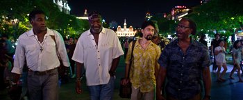 Movie still from “Da 5 Bloods” (2020), directed by Spike Lee – A group of men walking on the street at night; Medium shot, Low angle