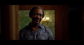 Movie still from “Da 5 Bloods” (2020), directed by Spike Lee – A person wearing glasses and smiling; Close Up shot, Over the shoulder angle