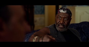 Movie still from “Da 5 Bloods” (2020), directed by Spike Lee – An older man sitting on a couch looking at the camera; Close Up shot, Over the shoulder angle