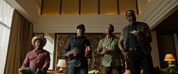 Movie still from “Da 5 Bloods” (2020), directed by Spike Lee – A group of men standing next to each other holding drinks; Medium shot, Low angle