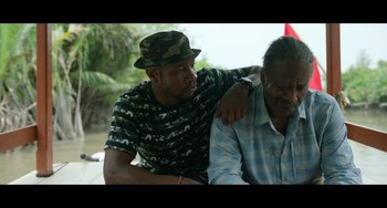 Movie still from “Da 5 Bloods” (2020), directed by Spike Lee – A man sitting next to another man on a bench; Medium shot, Over the shoulder angle