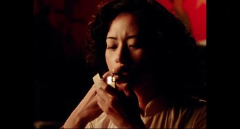 Movie still from “Da 5 Bloods” (2020), directed by Spike Lee – A woman is smoking a cigarette in a dark room; Close Up shot, Low angle