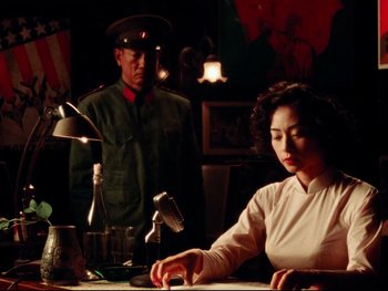 Movie still from “Da 5 Bloods” (2020), directed by Spike Lee – A woman sitting at a table in front of a man; Medium shot, Low angle