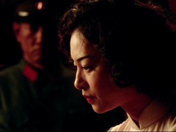 Movie still from “Da 5 Bloods” (2020), directed by Spike Lee – A person wearing a suit and tie; Close Up shot, Over the shoulder angle