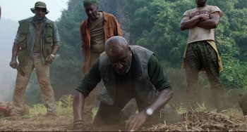 Movie still from “Da 5 Bloods” (2020), directed by Spike Lee – A group of men standing on top of a dirt field; Medium shot, Low angle