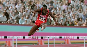 Movie still from “Da 5 Bloods” (2020), directed by Spike Lee – A man jumping over an obstacle in a track and field event; Medium shot, Low angle