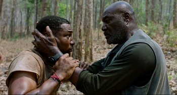 Movie still from “Da 5 Bloods” (2020), directed by Spike Lee – Two men in the woods one of whom is holding the other's face; Medium shot, Over the shoulder angle