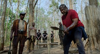 Movie still from “Da 5 Bloods” (2020), directed by Spike Lee – A group of men standing in the woods playing a game; Wide shot, Over the shoulder angle