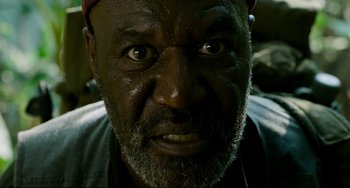 Movie still from “Da 5 Bloods” (2020), directed by Spike Lee – An old man with a beard and a red hat is looking at the camera; Extreme Close Up shot, Low angle